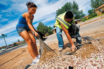 Youth Conservation Corps members Tracey Smitt, left, and Zach Smith work to clean the medians along Washington Avenue in Grants Thursday.— © 2009 Gallup Independent / Cable Hoover